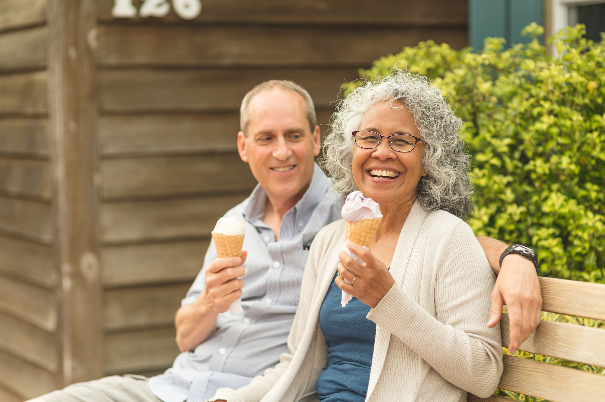 A senior couple enjoying ice cream cones on a summer afternoon.