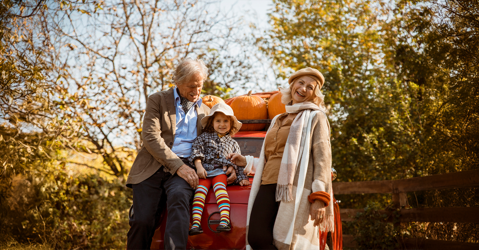 Senior couple in autumn vacation with their grandchild