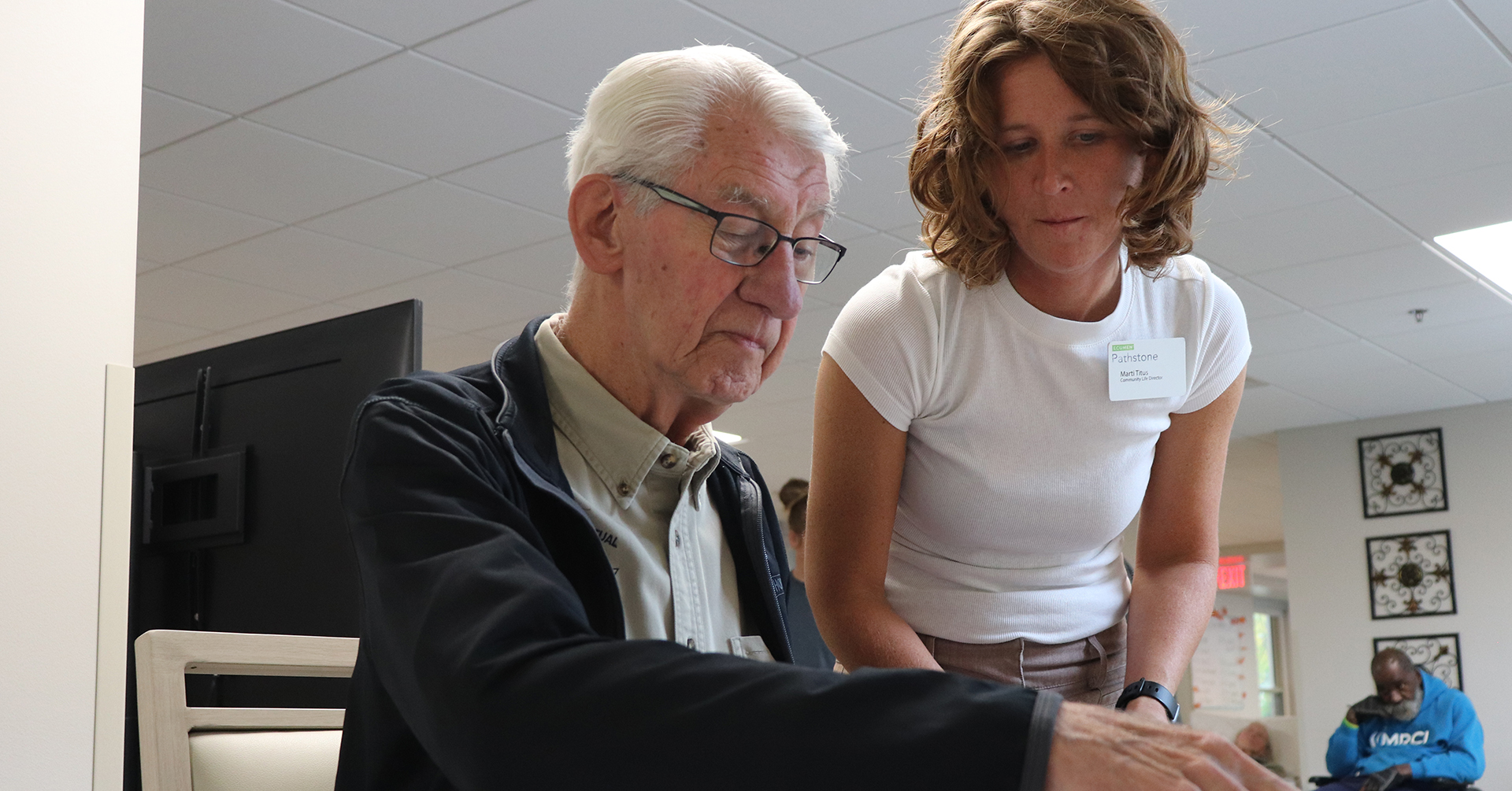 older male adult doing a puzzle with a caregiver